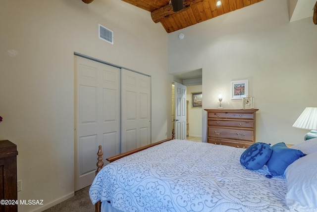 bedroom with a closet, carpet, wood ceiling, and high vaulted ceiling