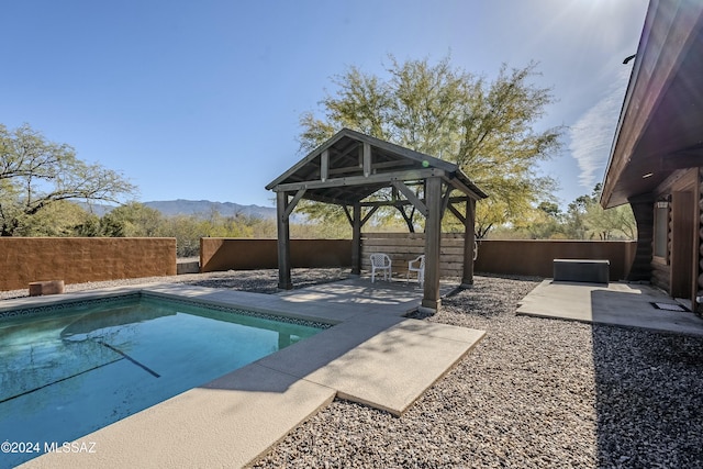 view of swimming pool featuring a mountain view, a gazebo, and a patio