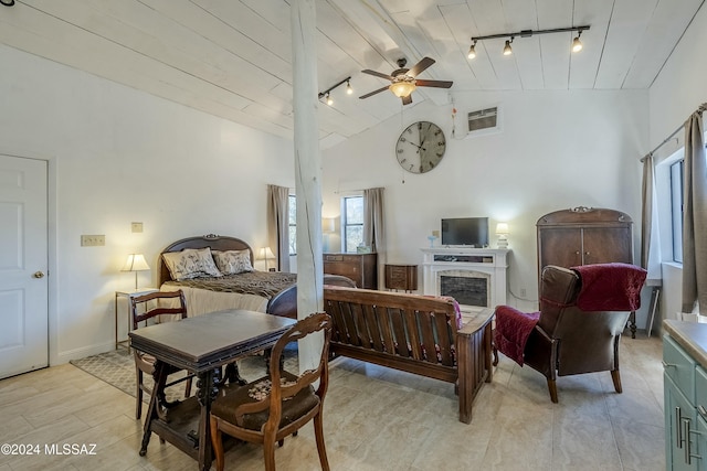 bedroom with ceiling fan, high vaulted ceiling, and track lighting