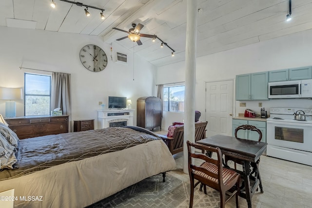 bedroom featuring beamed ceiling, rail lighting, high vaulted ceiling, and ceiling fan