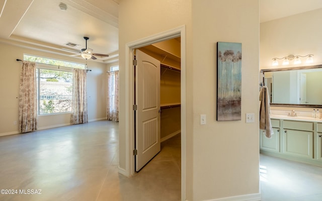 hall with a raised ceiling and sink