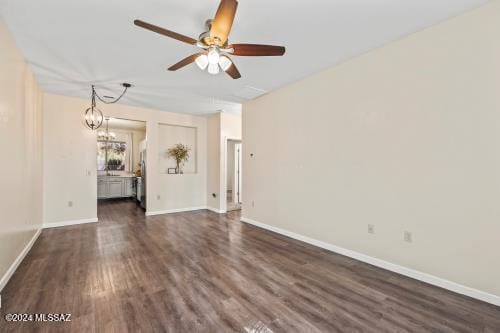 spare room featuring ceiling fan with notable chandelier and dark hardwood / wood-style flooring