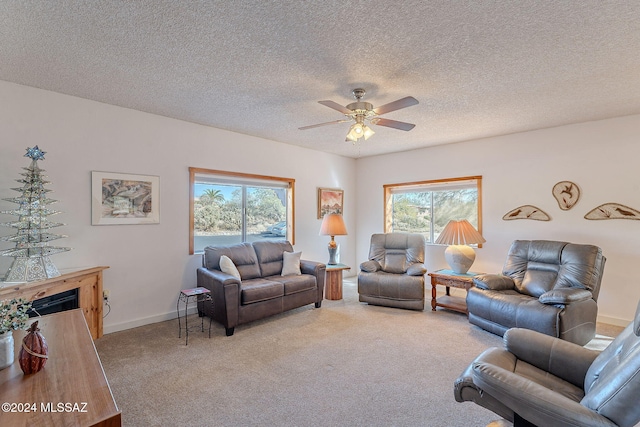 carpeted living room with plenty of natural light, a textured ceiling, and ceiling fan