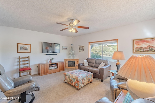 living room with ceiling fan, a textured ceiling, and light carpet