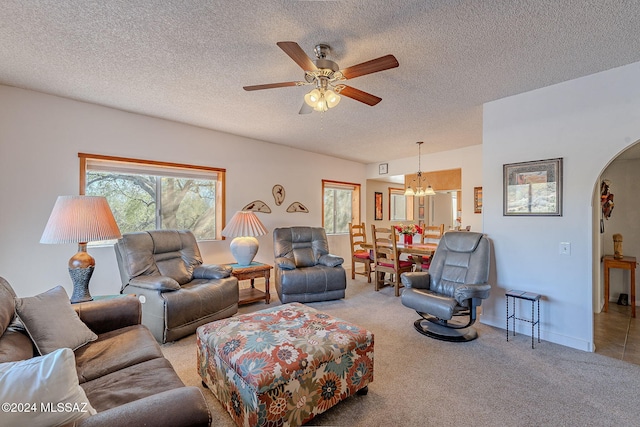 carpeted living room featuring ceiling fan and a textured ceiling