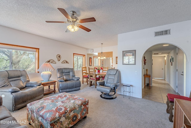 living room with ceiling fan, a wealth of natural light, a textured ceiling, and light carpet