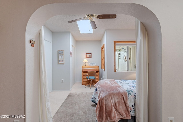 carpeted bedroom with ceiling fan and a textured ceiling