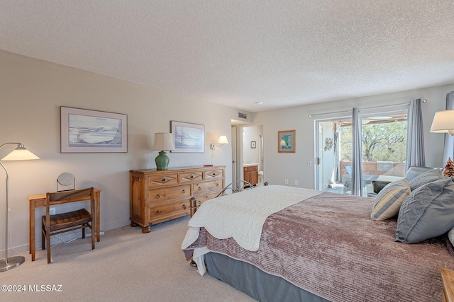 bedroom featuring access to exterior, light colored carpet, and a textured ceiling