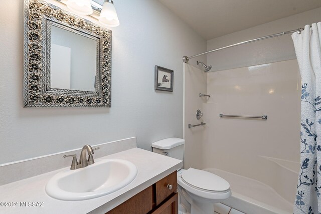 bathroom with curtained shower, toilet, and vanity