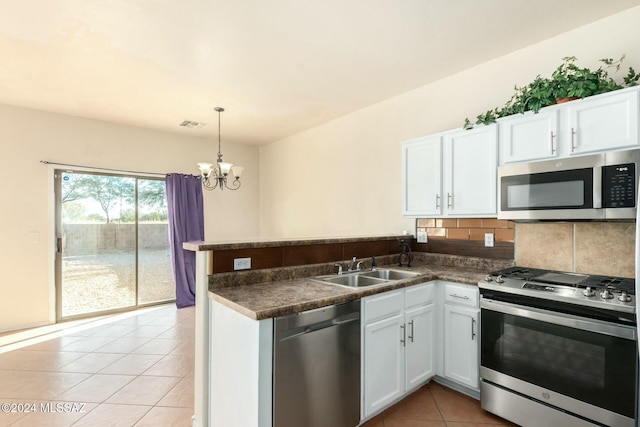 kitchen featuring tasteful backsplash, kitchen peninsula, white cabinets, and appliances with stainless steel finishes