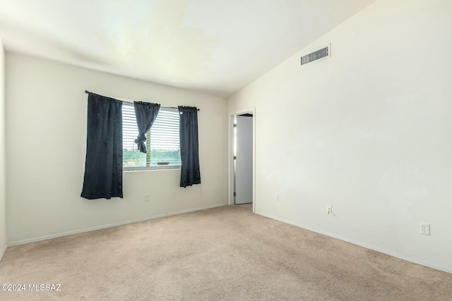 carpeted empty room with lofted ceiling