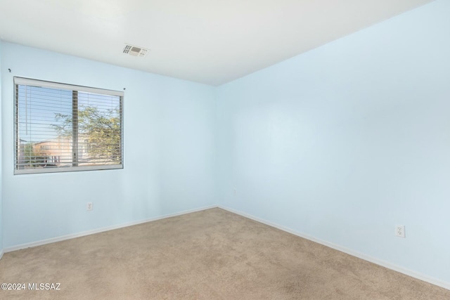 spare room featuring light colored carpet