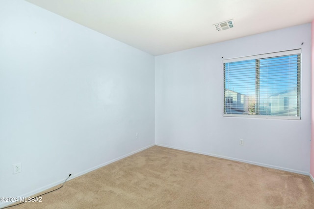 spare room featuring light colored carpet