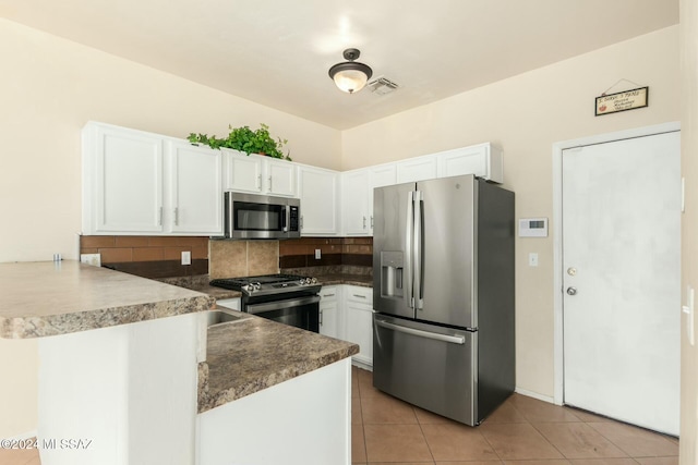 kitchen with kitchen peninsula, white cabinetry, stainless steel appliances, and decorative backsplash