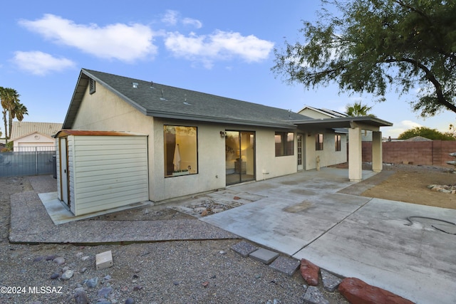 rear view of house featuring a patio and a garage