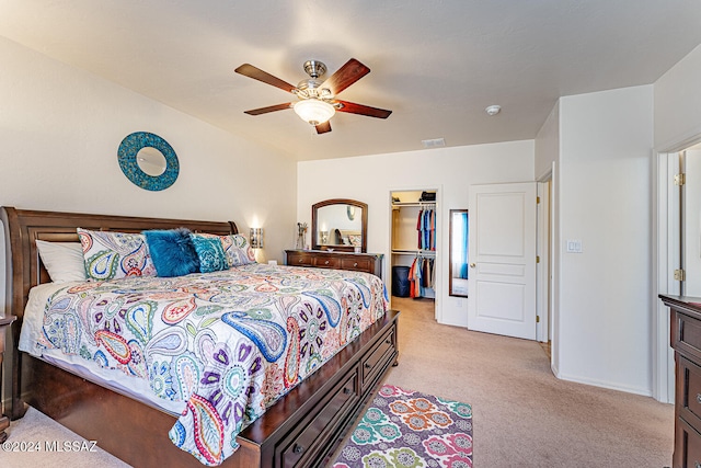 carpeted bedroom featuring a walk in closet, ceiling fan, and a closet