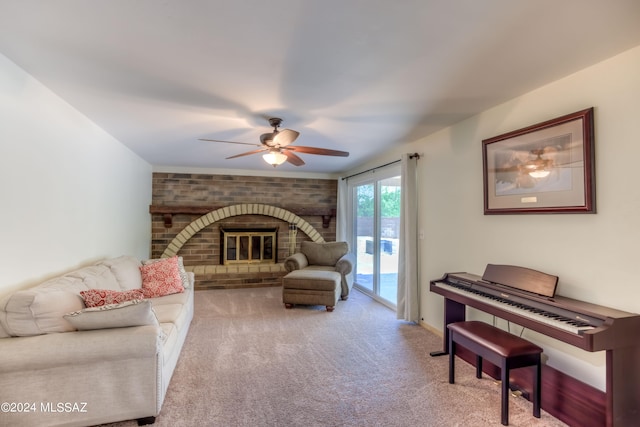 carpeted living room featuring ceiling fan and a brick fireplace