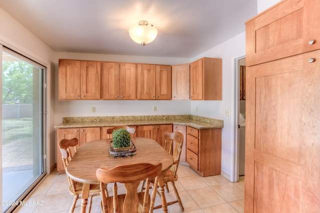 kitchen featuring light brown cabinets, light stone counters, and light tile patterned floors