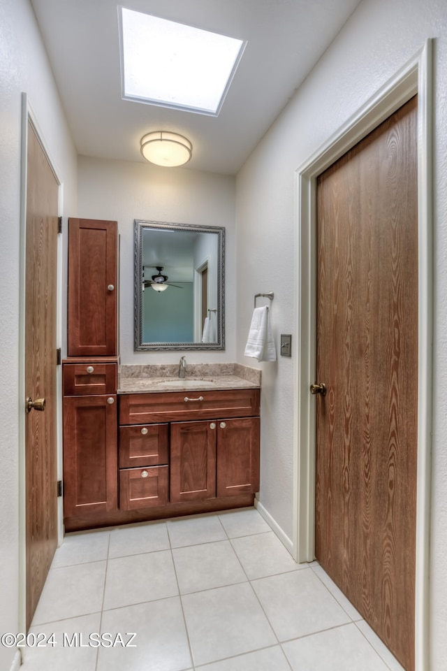 bathroom featuring a skylight, ceiling fan, tile patterned flooring, and vanity