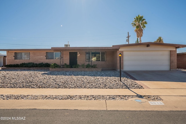 ranch-style house with a garage, concrete driveway, and brick siding