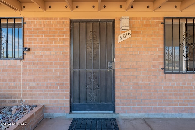 property entrance featuring brick siding