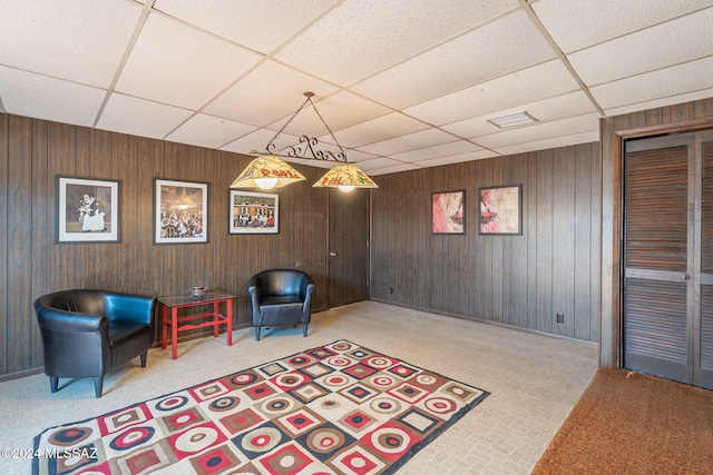 living area with light colored carpet and a drop ceiling