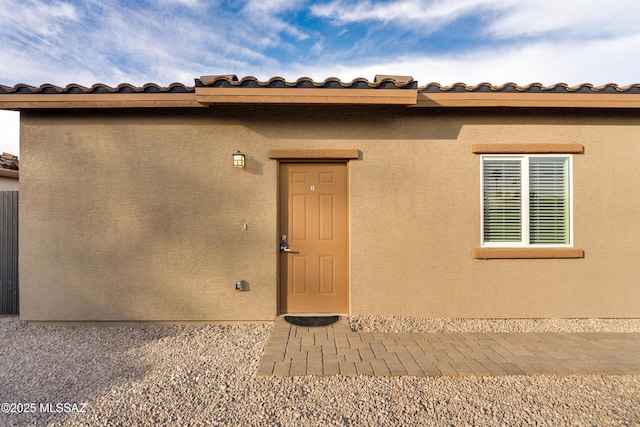 view of exterior entry featuring stucco siding