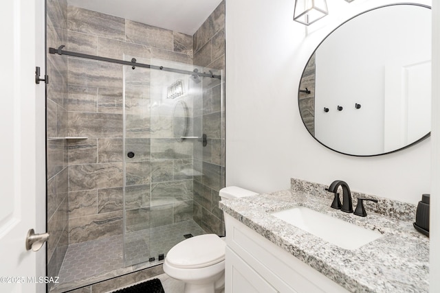 bathroom featuring a stall shower, vanity, and toilet