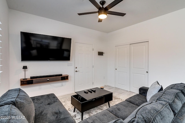 living area featuring ceiling fan and baseboards