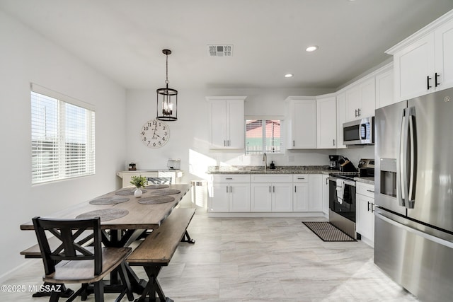 kitchen with visible vents, appliances with stainless steel finishes, white cabinets, and a sink