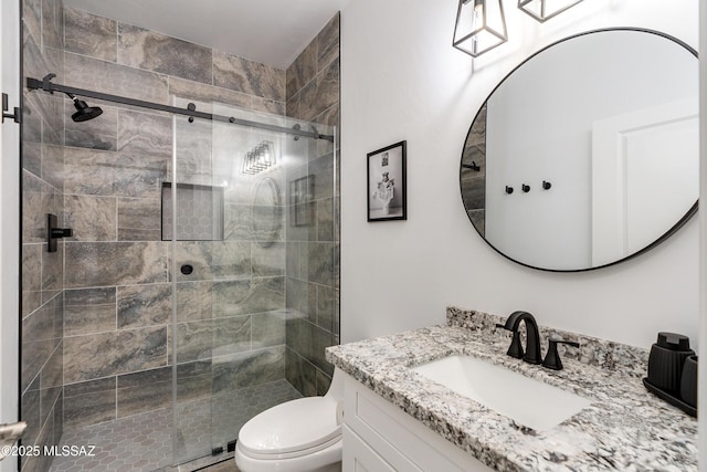 bathroom with walk in shower, vanity, and toilet