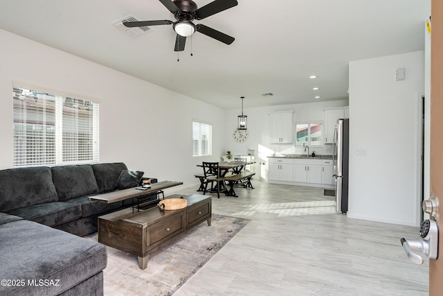 living area featuring a ceiling fan, recessed lighting, visible vents, and baseboards