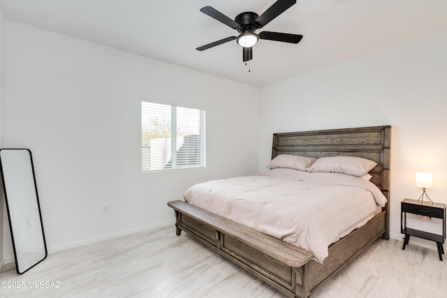 bedroom with a ceiling fan, marble finish floor, and baseboards