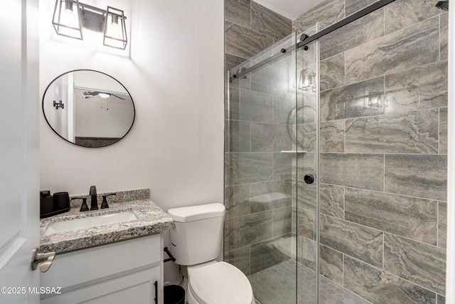 bathroom featuring a stall shower, vanity, and toilet