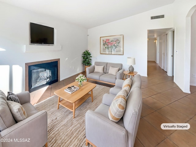 living room with tile patterned floors and vaulted ceiling