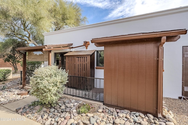 view of property exterior with a storage unit