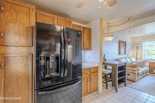 kitchen with black fridge, light tile patterned flooring, decorative light fixtures, and ceiling fan