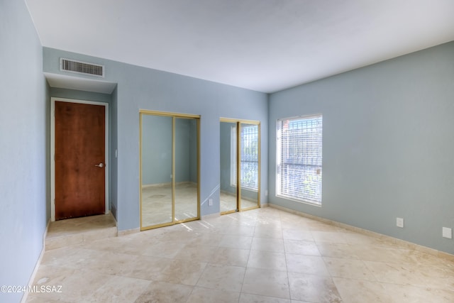 unfurnished bedroom featuring multiple closets