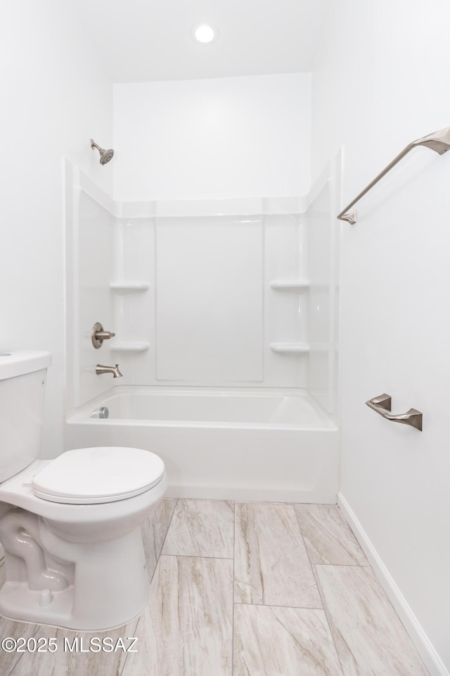 bathroom featuring shower / washtub combination and toilet