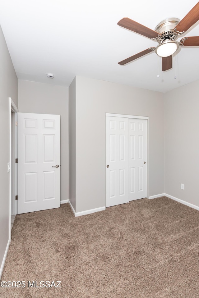 unfurnished bedroom with carpet flooring, ceiling fan, and a closet