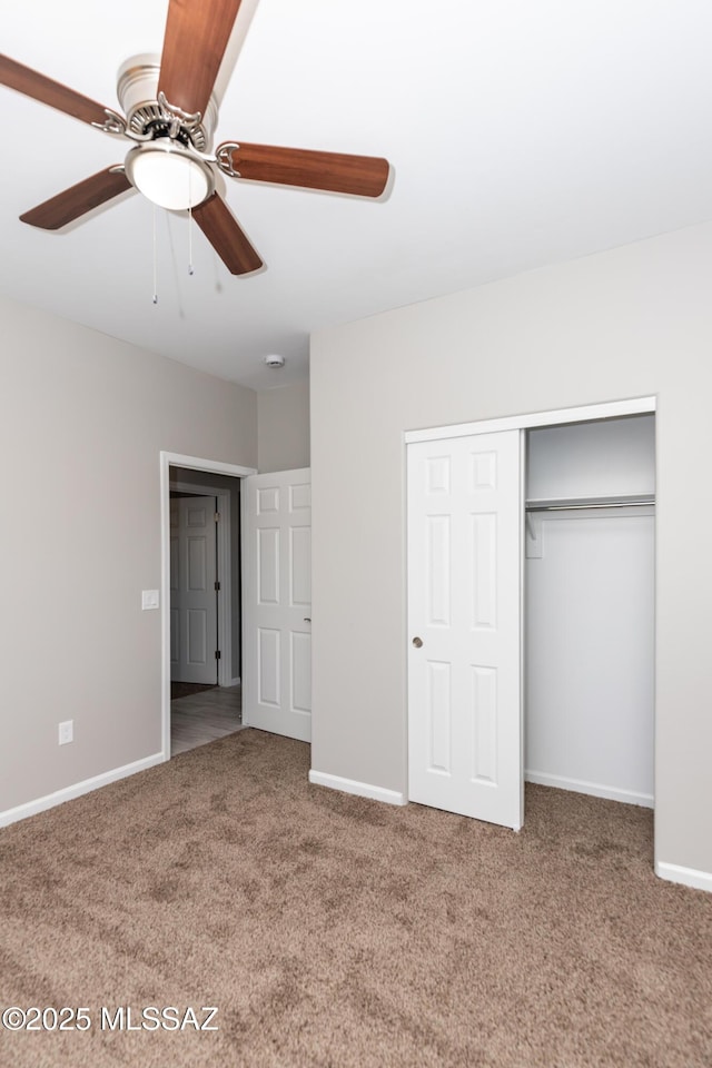 unfurnished bedroom with carpet, ceiling fan, and a closet