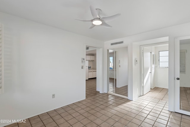 empty room featuring ceiling fan and light tile patterned floors