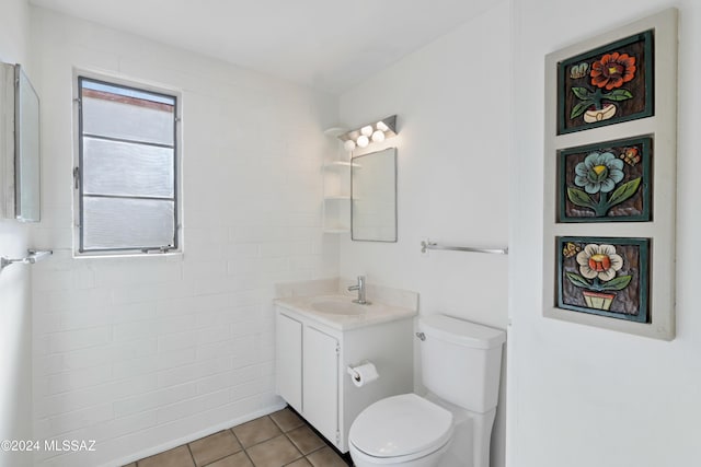 bathroom with toilet, vanity, and tile patterned floors