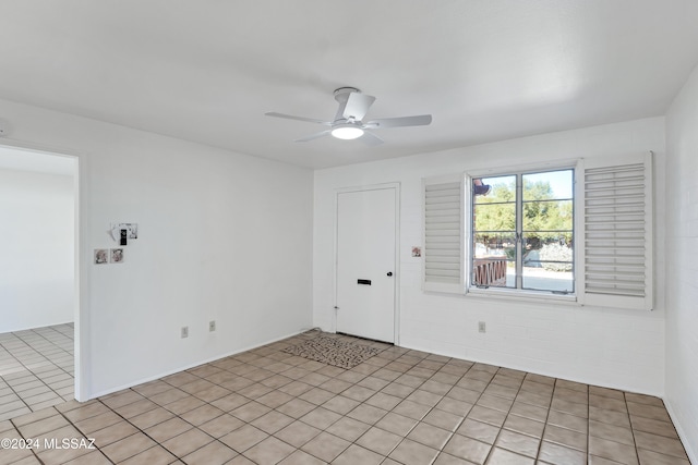 empty room with ceiling fan and light tile patterned flooring