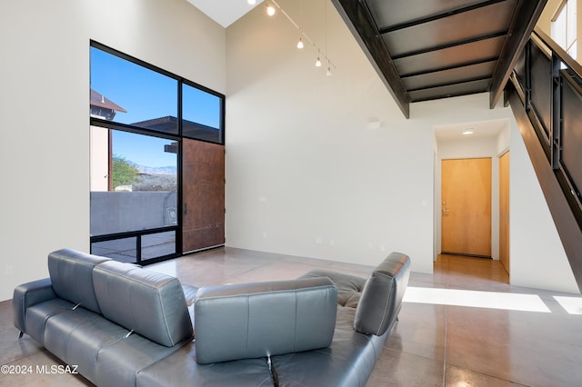 living room featuring a high ceiling and concrete floors