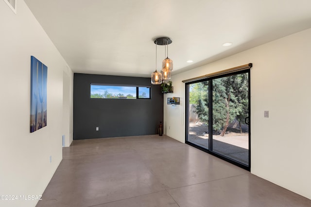 unfurnished dining area featuring concrete flooring