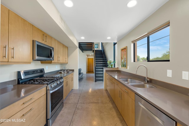 kitchen featuring light brown cabinetry, sink, and stainless steel appliances