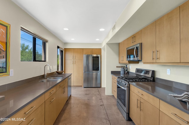 kitchen featuring appliances with stainless steel finishes, light brown cabinetry, and sink