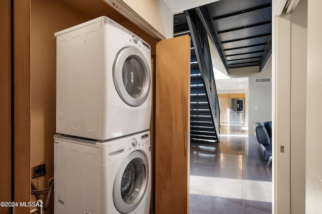 clothes washing area featuring stacked washer / dryer