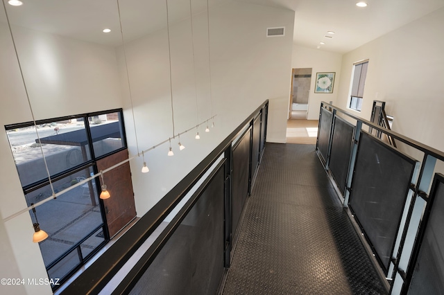 corridor featuring lofted ceiling, a wealth of natural light, visible vents, and recessed lighting